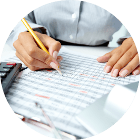 A person writing on a spreadsheet with a pencil